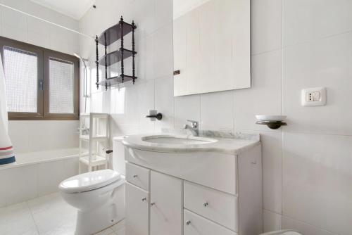 een witte badkamer met een toilet en een wastafel bij Brownie Home in Firgas