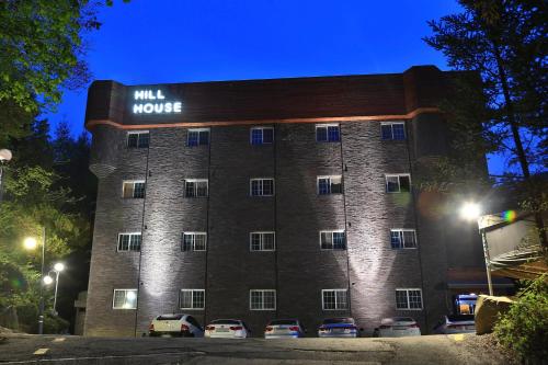 a large brick building with cars parked in front of it at Hill House Hotel in Pocheon