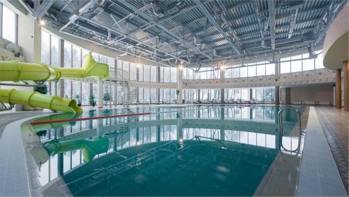 una gran piscina con un tobogán de agua en un edificio en Arthurs Spa Hotel By Mercure, en Larevo