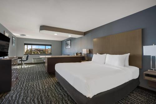 ボイジーにあるHotel 28 Boise Airport, an Ascend Collection Hotelの大きなベッドと机があるホテルの部屋