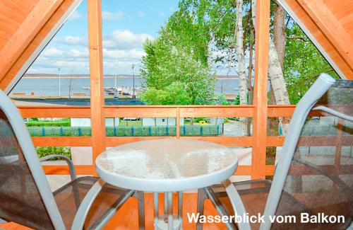 ドンプキにあるFH Romaniuk Nr4の海が見えるバルコニーにテーブルと椅子がある