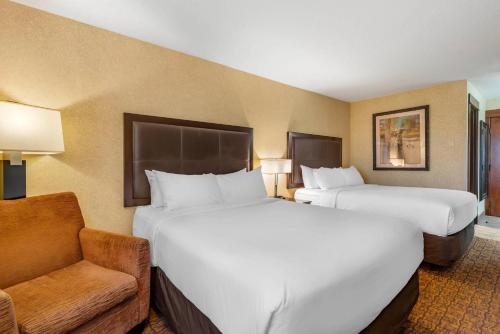 a hotel room with two beds and a chair at Lloyd Hotel Astoria Bayfront, an Ascend Collection Hotel in Astoria, Oregon