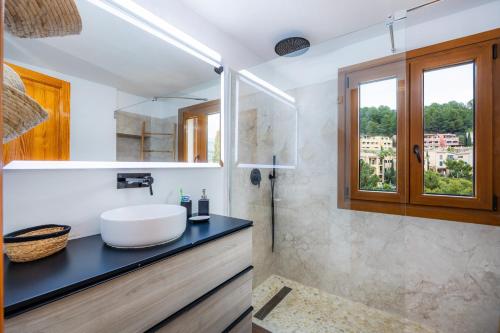 une salle de bain avec un lavabo blanc et une fenêtre dans l'établissement Villa Carla, à Port de Sóller