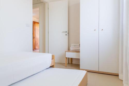 a white bedroom with a bed and a closet at Baseventuno 2 - Trilocale primo piano in Sirmione