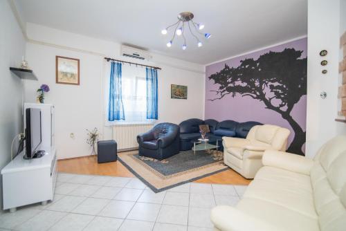 a living room with a tree painted on the wall at Apartment Sweet Dreams in Sutivan