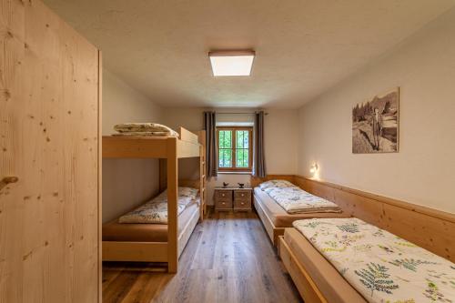 a room with three bunk beds and a window at Schildhof Ebion Familienwohnung in San Leonardo in Passiria