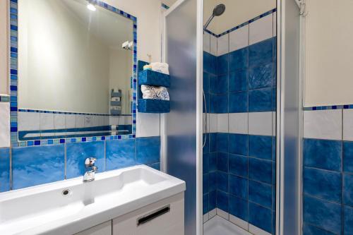 カステルサルドにあるPetra Marisの青いタイル張りのバスルーム(シンク、シャワー付)