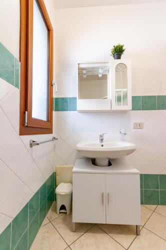 a bathroom with a sink and a mirror at Appartamento Pina Caletta sul mare con parcheggio privato in La Caletta