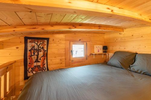 a bed in a log cabin with a window at Chalet in Saujon