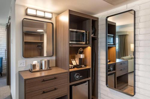 a room with a kitchen with a large mirror at The Gibson Hotel Great Falls, an Ascend Collection Hotel in Great Falls