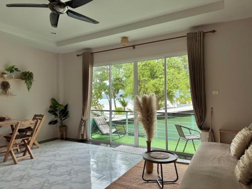 a living room with a large sliding glass door with a patio at Sea Dreamer Beachfront Apartments in Phuket