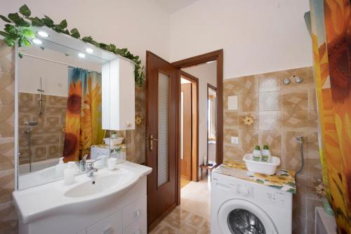 a bathroom with a sink and a washing machine at I Girasoli in Alassio