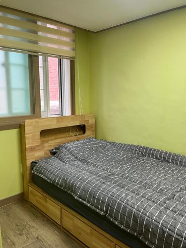 un dormitorio con una cama y una ventana en 전북대근처 시외버스터미널 원룸3, en Haga-ri