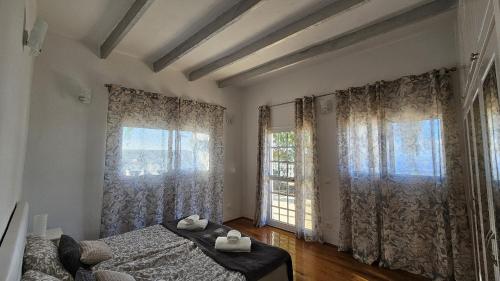 une chambre avec un lit et deux grandes fenêtres dans l'établissement Cool 4-bedroom Villa with sea views, à Tijoco de Abajo