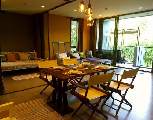 - un salon avec une table et des chaises en bois dans l'établissement The Valley Escape สองห้องนอน สวย สงบ สบาย, à Phayayen