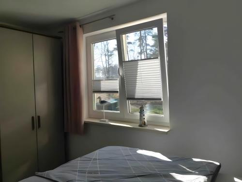 a bedroom with a bed and two windows at Fewo Ostseebuhne Graal-Müritz in Gelbensande