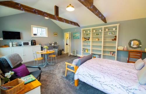 a bedroom with a bed and a living room at The Den - Winchelsea in Winchelsea