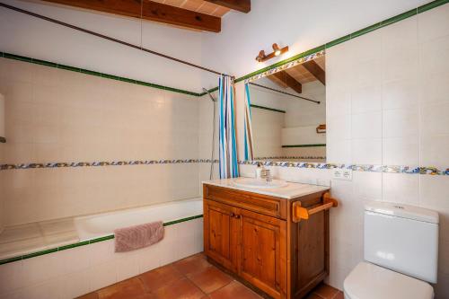 a bathroom with a sink and a toilet and a tub at Can Patró in Manacor