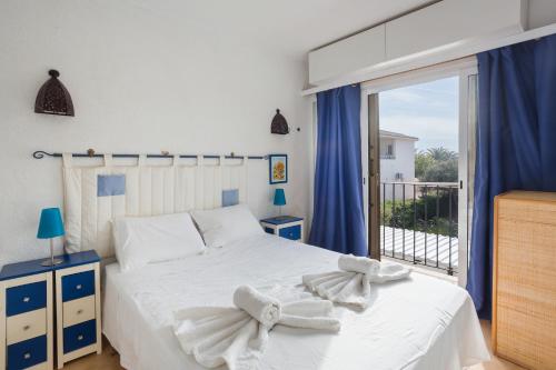 una camera da letto con un letto bianco e un balcone di Nueva Playa a Denia