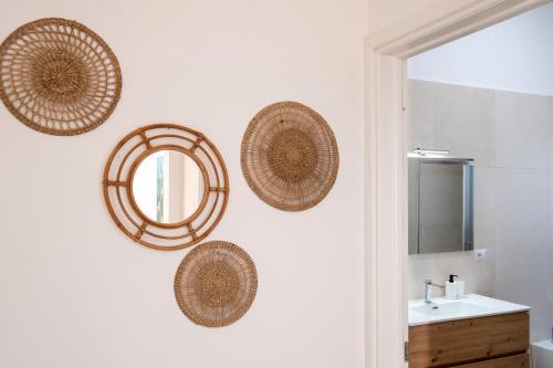 a bathroom with wicker baskets on the wall at Arvèa – Lux Coastal Essence in Torre Lapillo