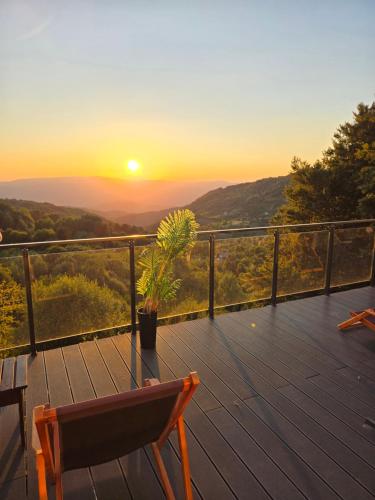 コパオニクにあるKopaonik Milmari & Spa N Lux 90の椅子と植物のあるデッキでの夕日