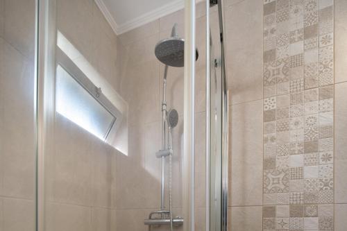 a shower with a glass door in a bathroom at Nuria House in Praia da Vitória