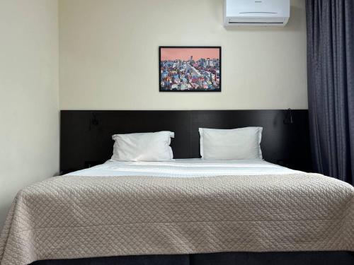 a bedroom with a large bed with a black headboard at Alma in Almaty