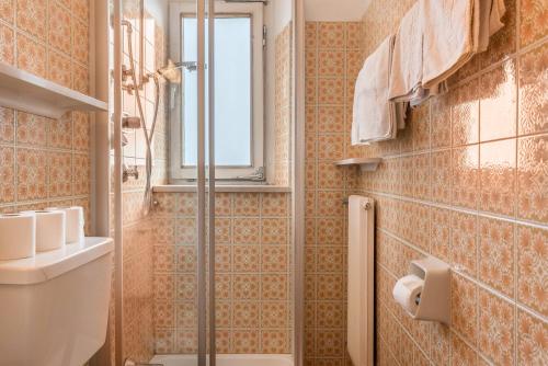 une salle de bain avec douche et toilettes et une fenêtre dans l'établissement Adang Ferienwohnung Fernblick, à Tirolo
