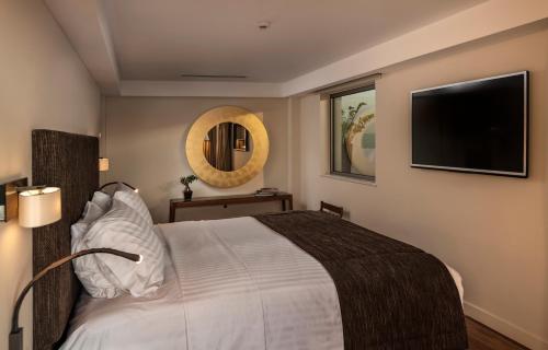 a bedroom with a bed and a television on the wall at Samaria Hotel in Chania Town