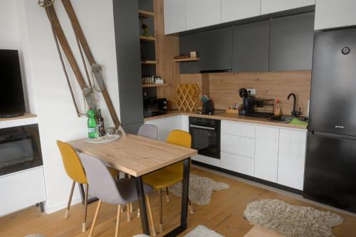a kitchen with a wooden table and yellow chairs at Apartment - Vucica in Bjelašnica