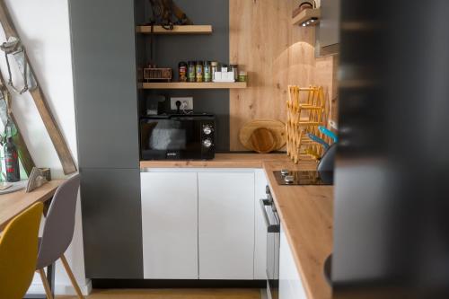 a kitchen with white cabinets and a black microwave at Apartment - Vucica in Bjelašnica