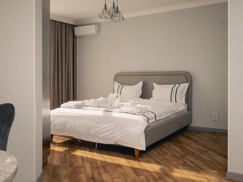 a bedroom with a bed with white sheets and pillows at 71 East Apart Hotel in Astana