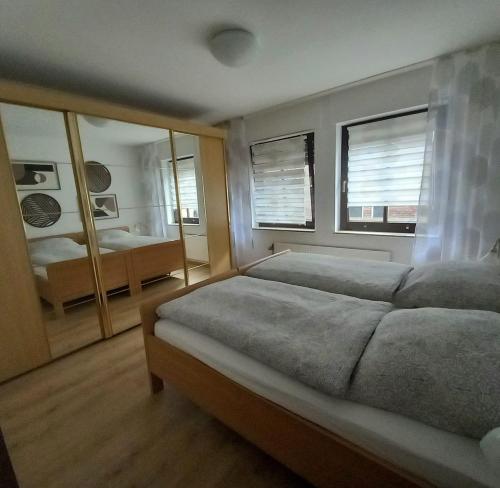 a bedroom with two beds and two windows at Ferienwohnung an der Kriemhildmühle in Xanten