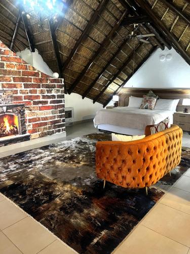 a bedroom with a fireplace and a bed and a couch at Wood Valley in Midrand