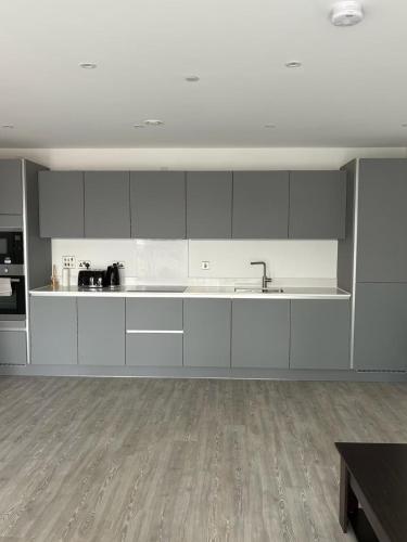 une cuisine avec des armoires blanches et un plancher en bois dans l'établissement Fully furnished 2 bedroom complete Apartment for 5 Guest, à CBG