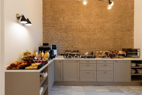 a kitchen with a counter with aasteryasteryasteryasteryasteryasteryasteryasteryastery at Colectia Hotel Parada del Marqués in Seville