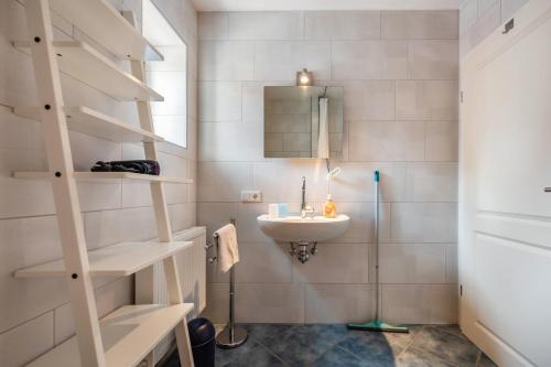 ein kleines Badezimmer mit Waschbecken und Spiegel in der Unterkunft Bi Pasders in Nordstrand