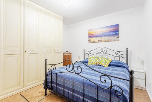 パレルモにあるLa Casa Di Alina Mondelloのベッドと壁に絵が飾られた寝室