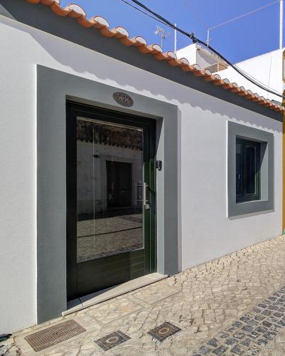 a door on a white building with a tile floor at Casa da Vila in Vila Real de Santo António