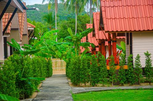 a walkway between two houses with trees and plants at Lanta Family resort in Ko Lanta