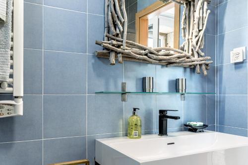 a bathroom with a white sink and blue tiles at Casa Azul in Moledo