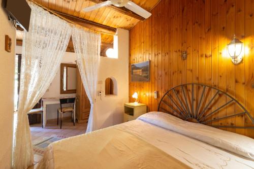 Un dormitorio con una cama grande con una pared de madera. en Fattoria Spezia - Nespola, en Buseto Palizzolo