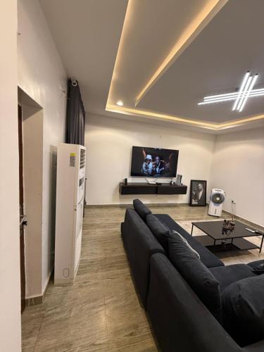a living room with a couch and a tv at Sunset Yard in Abuja