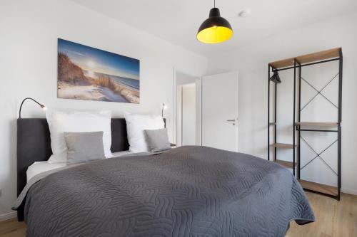 Un dormitorio con una cama grande con almohadas blancas. en Das Strandhaus am Dümmer See, en Lembruch