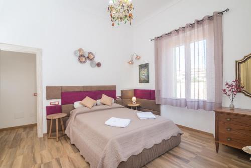 une chambre avec un grand lit et une fenêtre dans l'établissement Maison Chloe, à La Maddalena