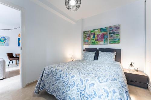a bedroom with a bed with a blue and white bedspread at Mi Patio, Port Of Cabopino in Marbella