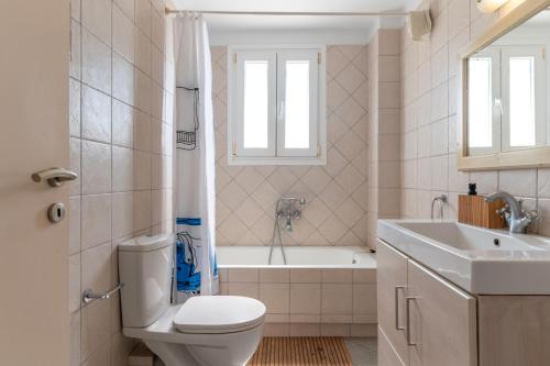 een badkamer met toilet, bad en wastafel bij Sun Blooming Villa In Tinos Island in Agios Romanos