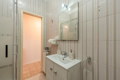 a white bathroom with a sink and a mirror at Casa di Nonna Tosca Montecarlo in Montecarlo