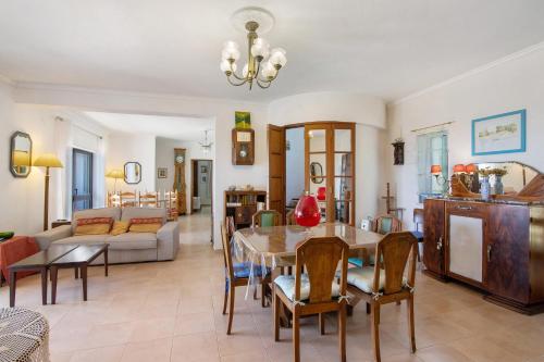 een woonkamer met een tafel en een bank bij Villa La Ribeyre in Boliqueime