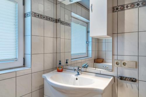 バート・ペーターシュタル・グリースバッハにあるBrumichelhofの洗面台と鏡のある白いバスルーム